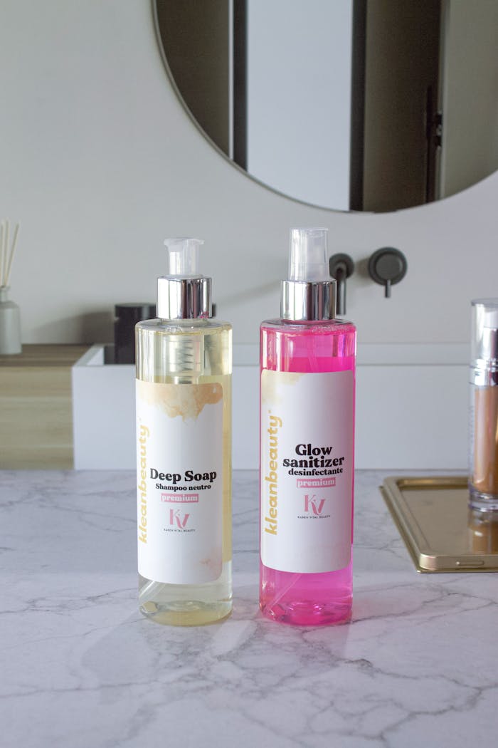 Elegant display of soap and sanitizer bottles on a marble counter, perfect for skincare themes.